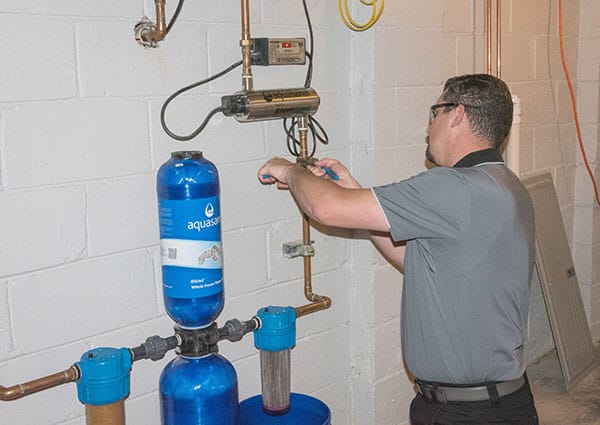 plumbing technician servicing a water filtration system