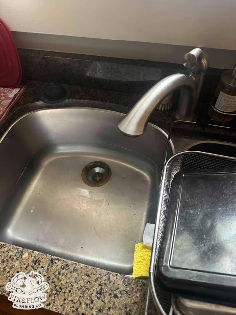 Slow Draining Sink Image. Plumber is investigating