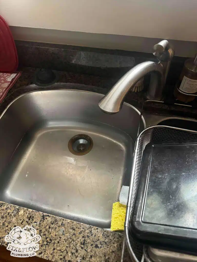 Slow Draining Sink Image. Plumber is investigating