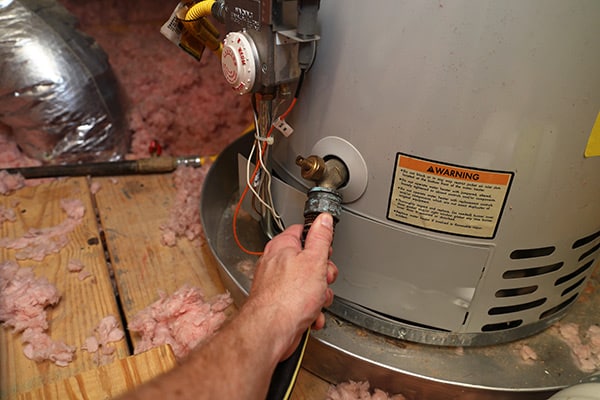 Plumber inspecting and finding a need for Water Heater Drain repair.
