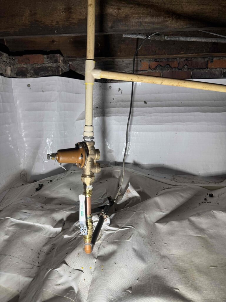 Completed installation of brass shutoff valve, Watts PRV, and CPVC tee connection, fully sealed and leak-tested.